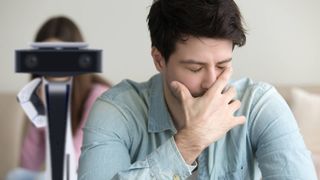 Man looking upset with PS5 HD Camera behind him