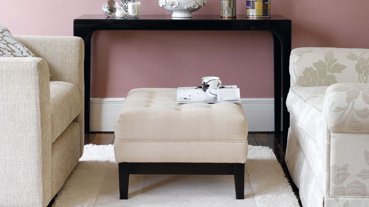 Cream coloured ottoman and sofas, cream rug, dark wood console table