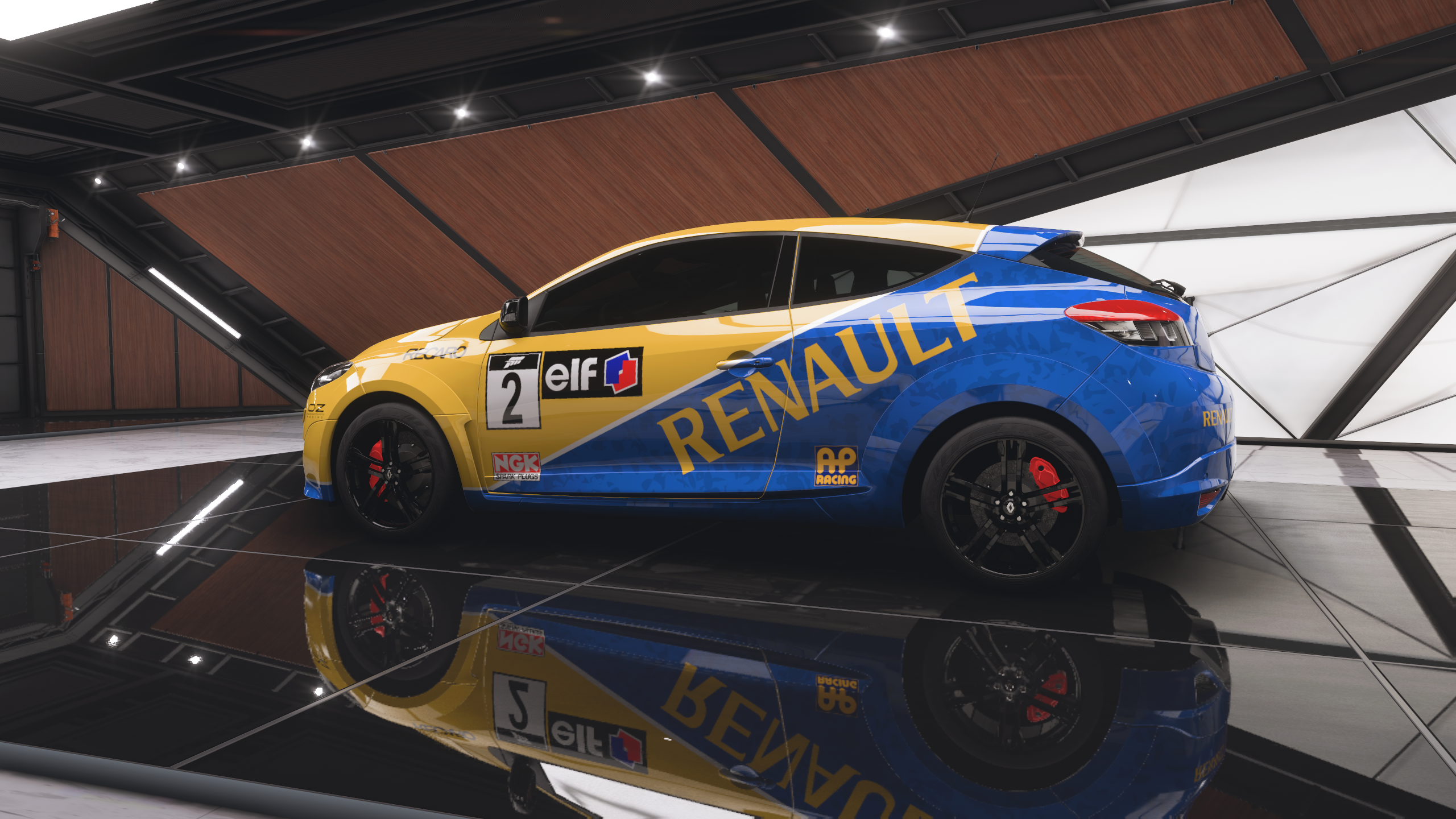 A blue and yellow Renault race car with branding sits in the Forza Horizon 5 ForzaVista. The sleek design and reflective floor exude a dynamic, sporty vibe.