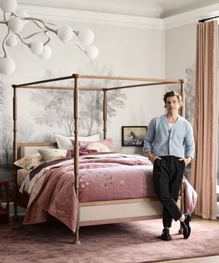 jeremiah brent for crate & barrel kids portrait image of the designer stood next to a four poster bed in a pink bedroom