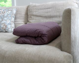 Folded purple weighted blanket on couch