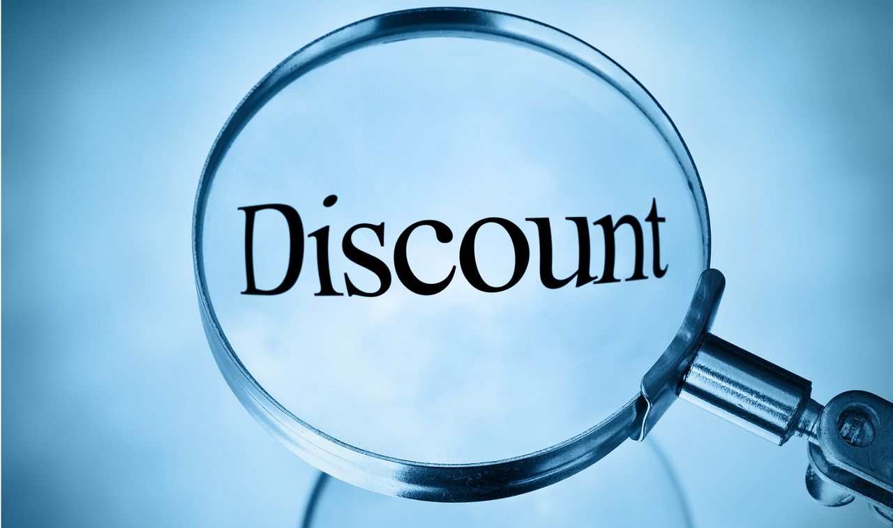 Magnifying glass over the word &quot;discount&quot; on blue background.