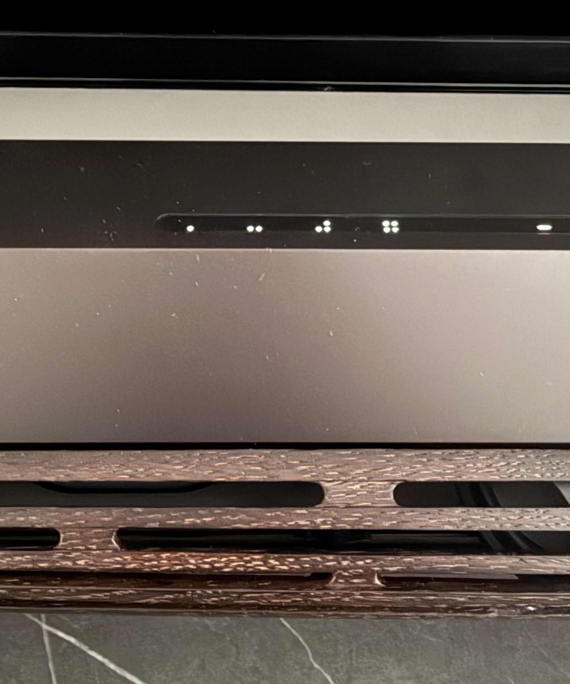 Close-up of the Beosound Premiere touch control panel showing illuminated LED indicators along a slim strip on the top surface