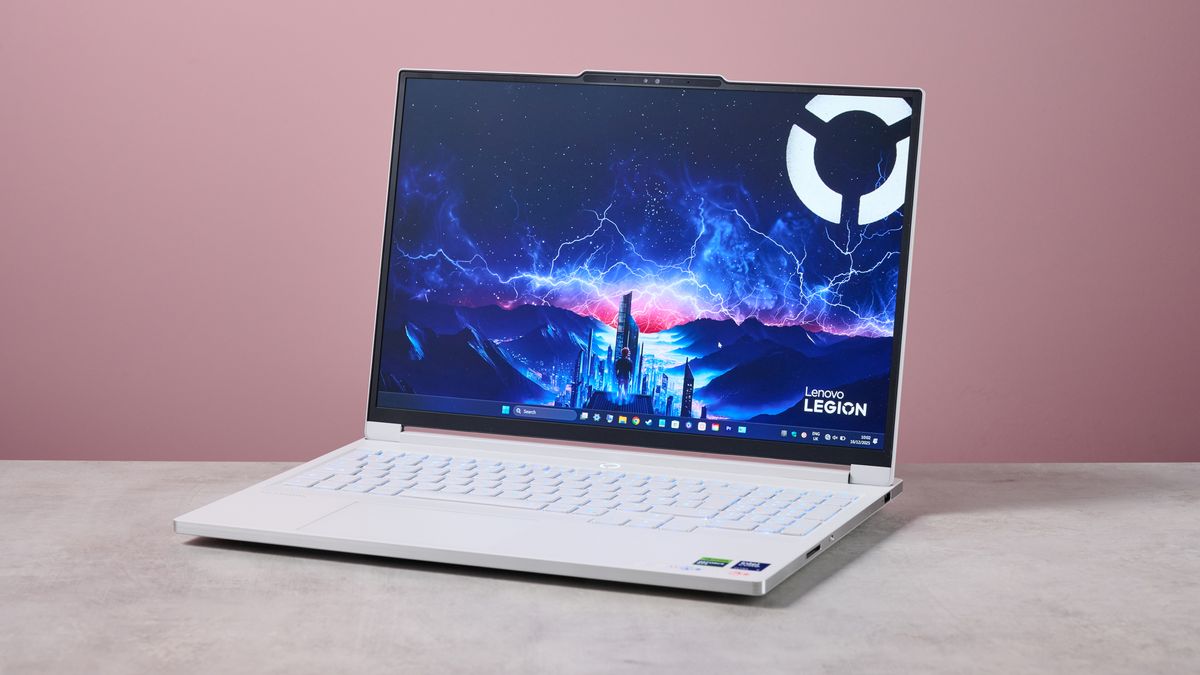 Three-quarter view of Lenovo Legion 7i Gen 10 open on desk with pink wall in background