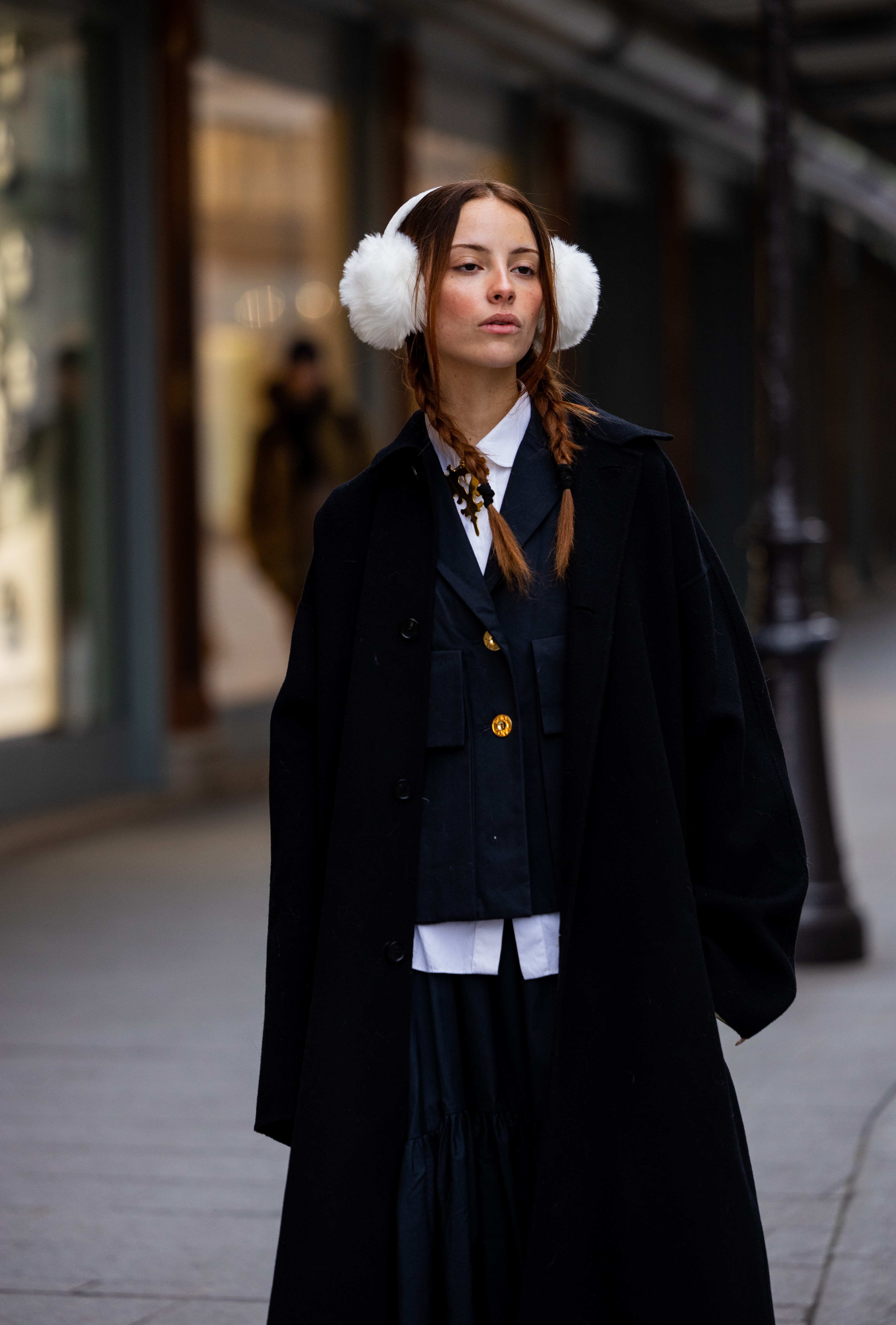 PARIS, FRANCE - JANUARY 27: A guest wears ear warmers, black coat, yellow bag, navy jacket, white button shirt outside Patou at La Samaritaine on January 27, 2023 in Paris, France. (Photo by Christian Vierig/Getty Images)