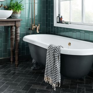 bathroom with green tiled walls and grey tiled flooring