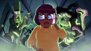 Velma flanked by green ghosts
