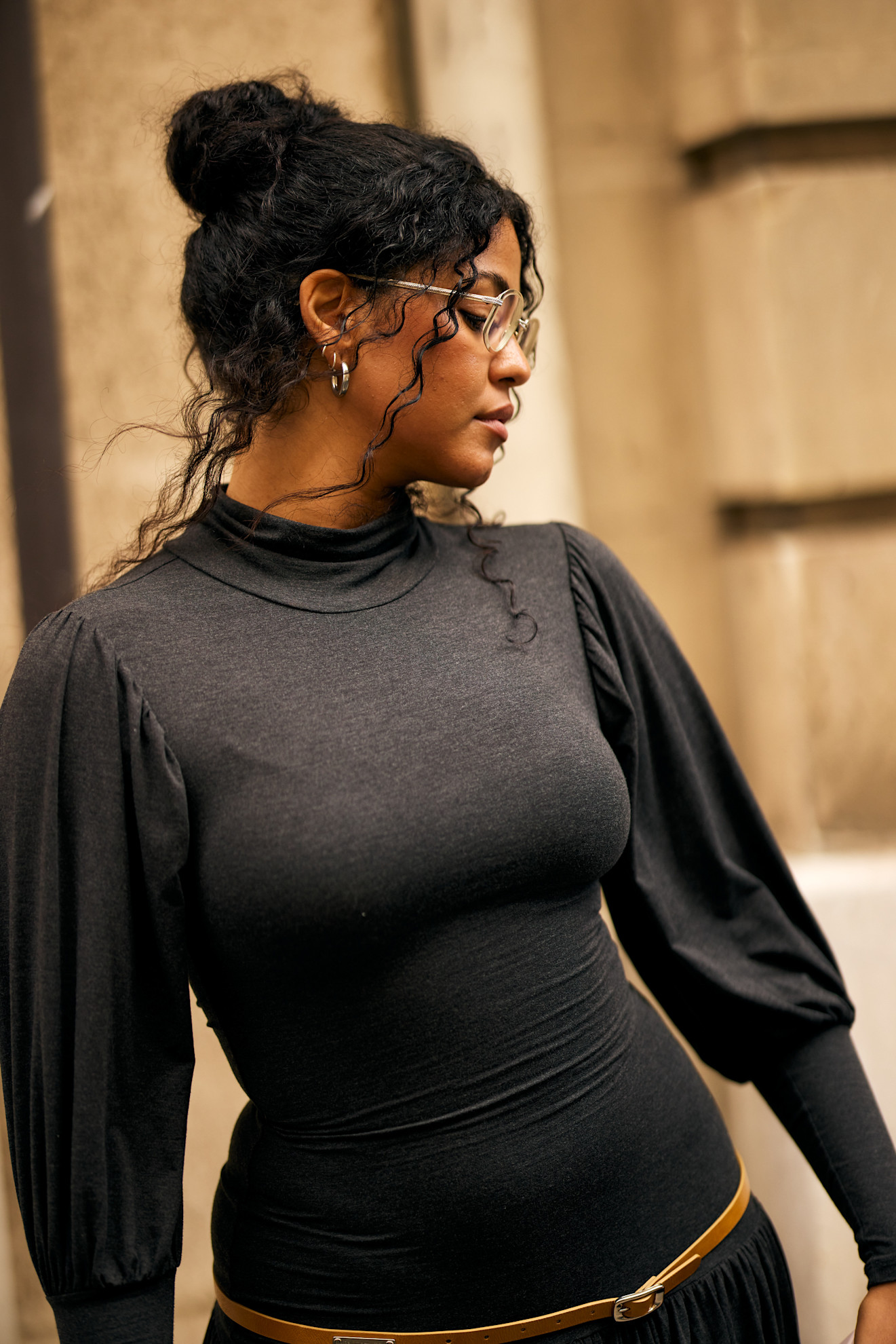 a black woman with a curly updo in a gray sweater