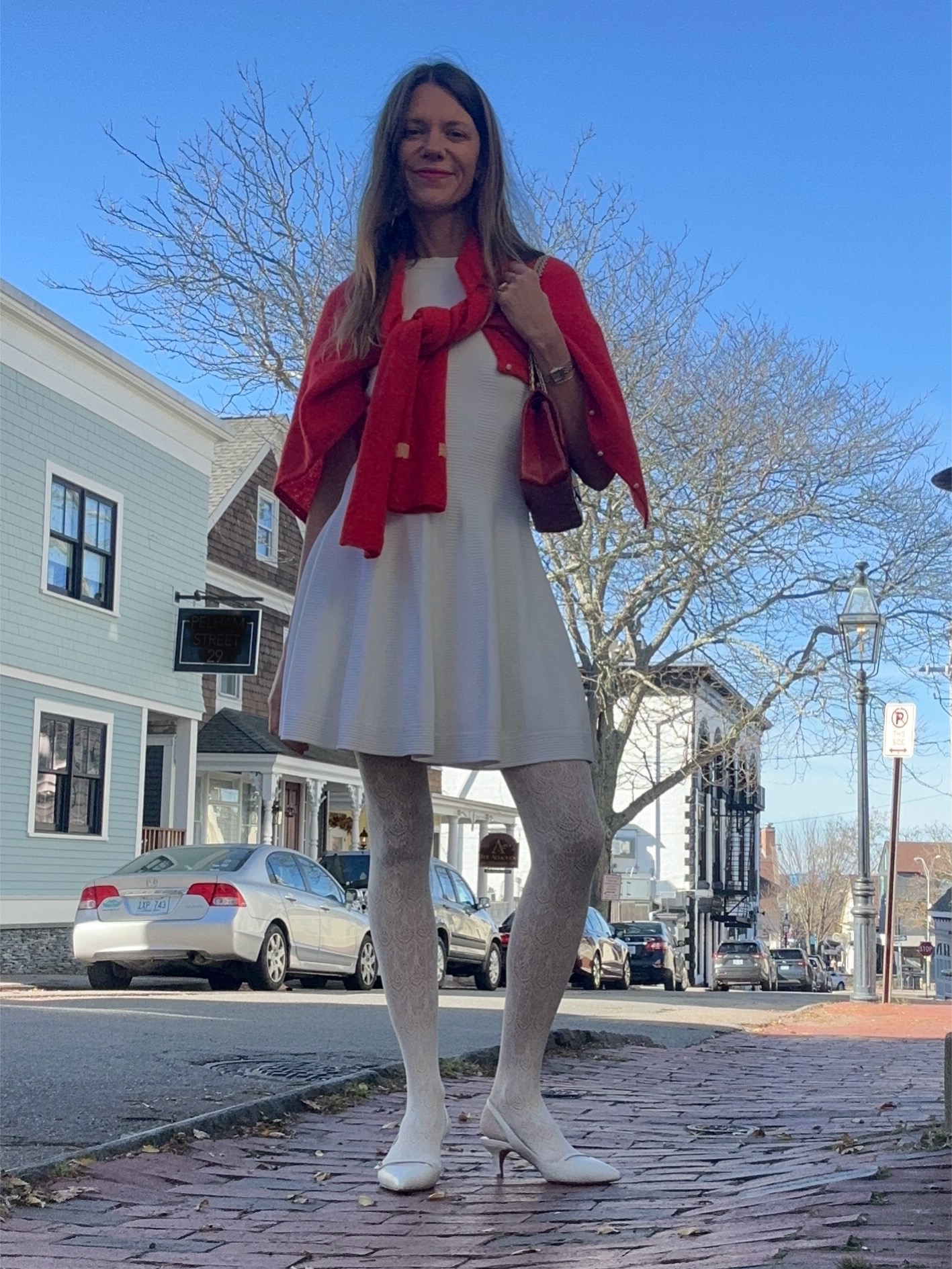 Julia Gall wearing white lace tights with a white dress and red cardigan
