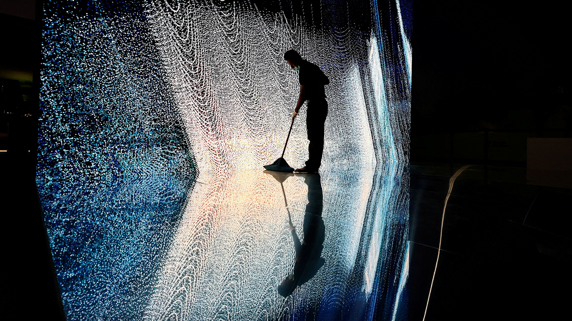 A cleaner mops the floor near an art installation ahead of the Noor Riyadh light festival in Riyadh, Saudi Arabia