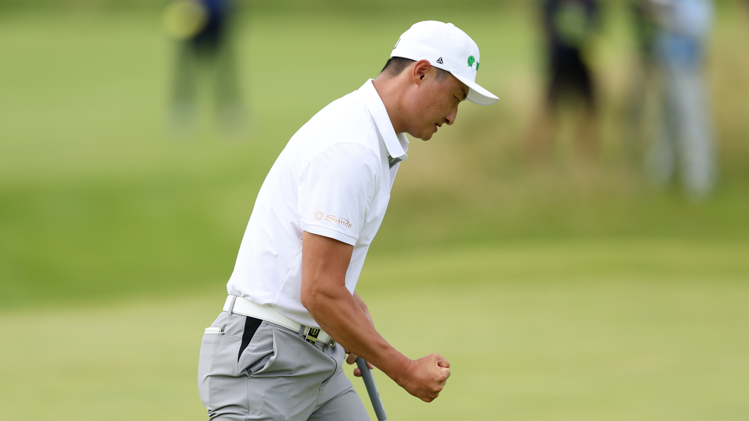 Haotong Li celebrates holing a putt at The Open