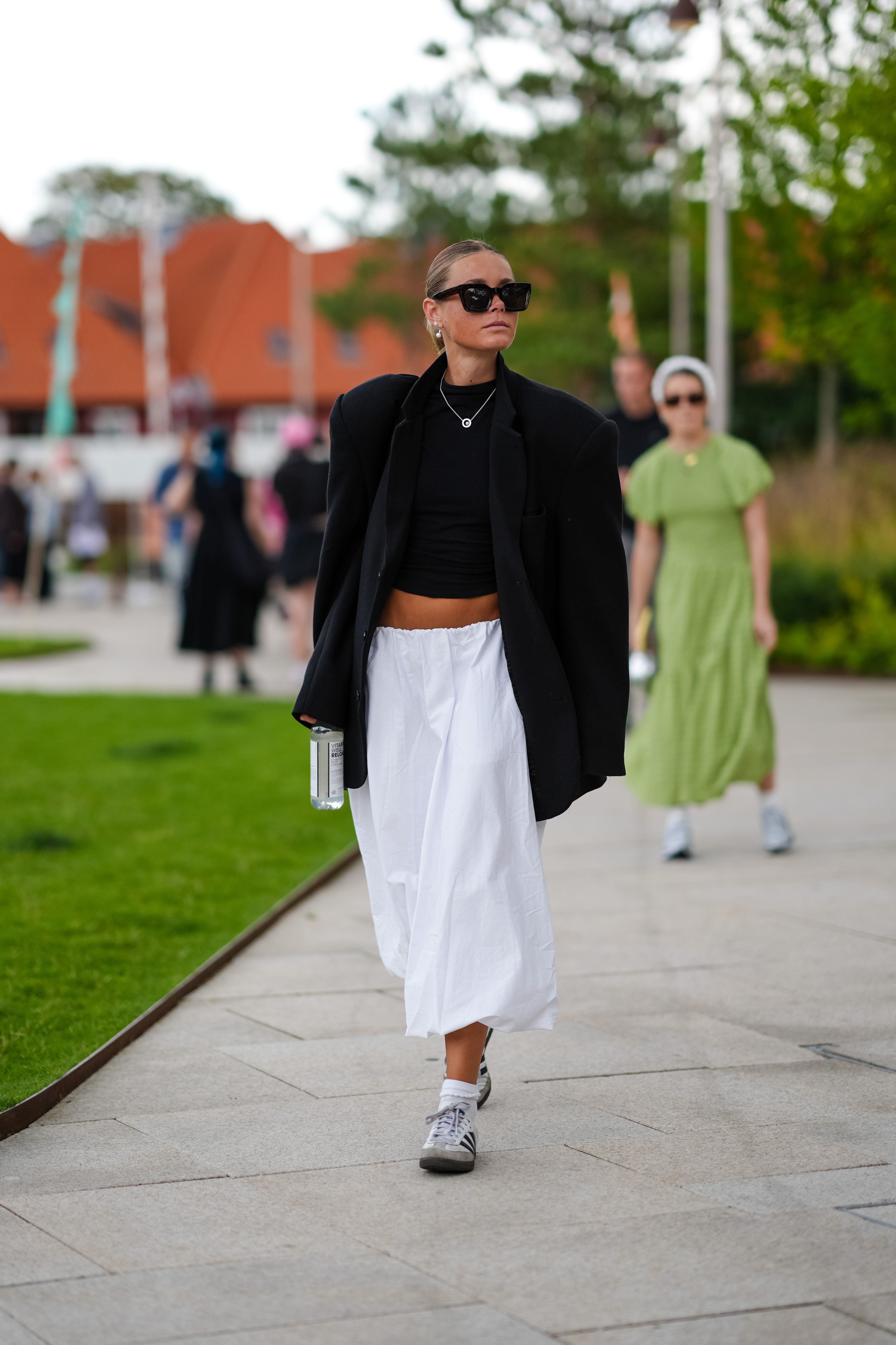 woman wearing blazer, white skirt, and sambas