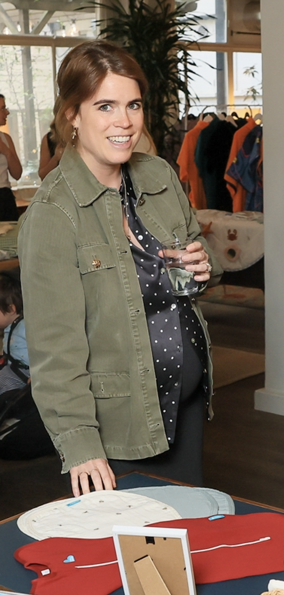 Princess Eugenie wearing a green jacket holding a glass of water