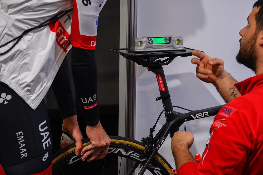 The UAE Team Emirates mechanic checks the level of a rider's saddle