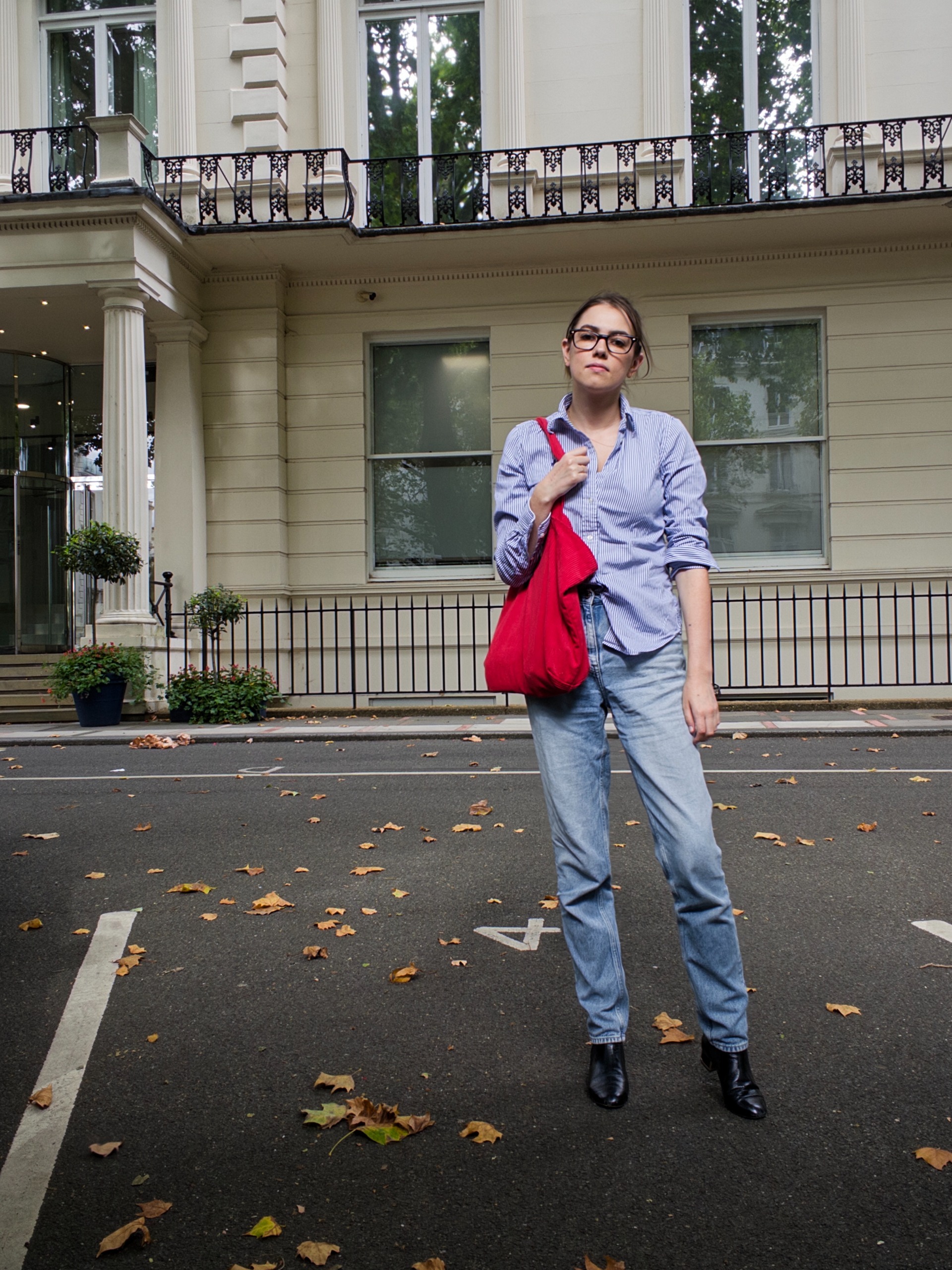 Jenny Hollander wearing a blue shirt and lightwash jeans and a large red tote bag