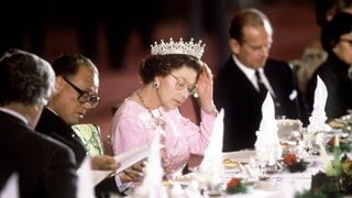 The Queen Adjusting Her Tiara Whilst Reading The Menu Before Dinner Is Served