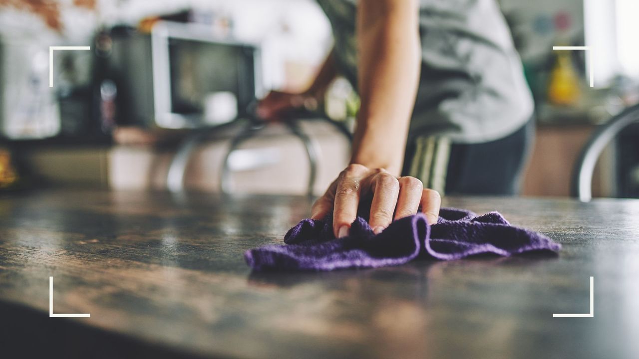  woman cleaning table with a microfibre cloth to answer can you use malt vinegar for cleaning