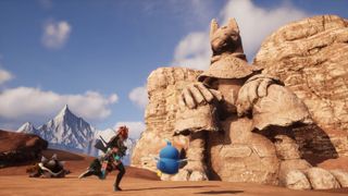 Players advance towards a large ancient statue in the desert