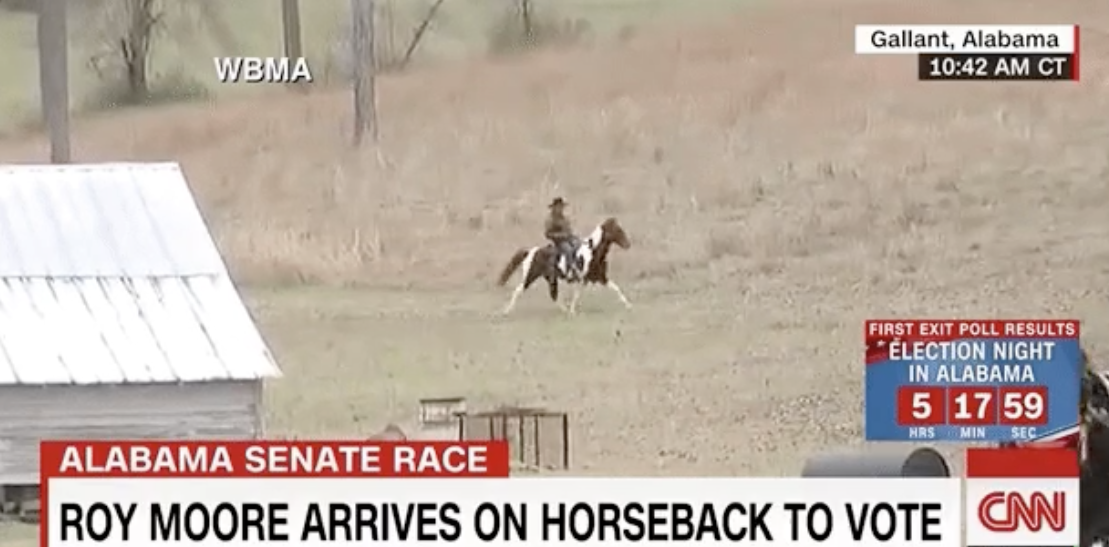 Roy Moore arrives to vote on horseback.