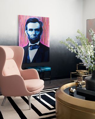 A room with pink armchair and a painting on wall