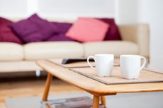 two coffee mugs on a table in front of a couch