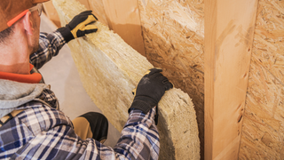 Person placing internalm wall insulation onto a wall