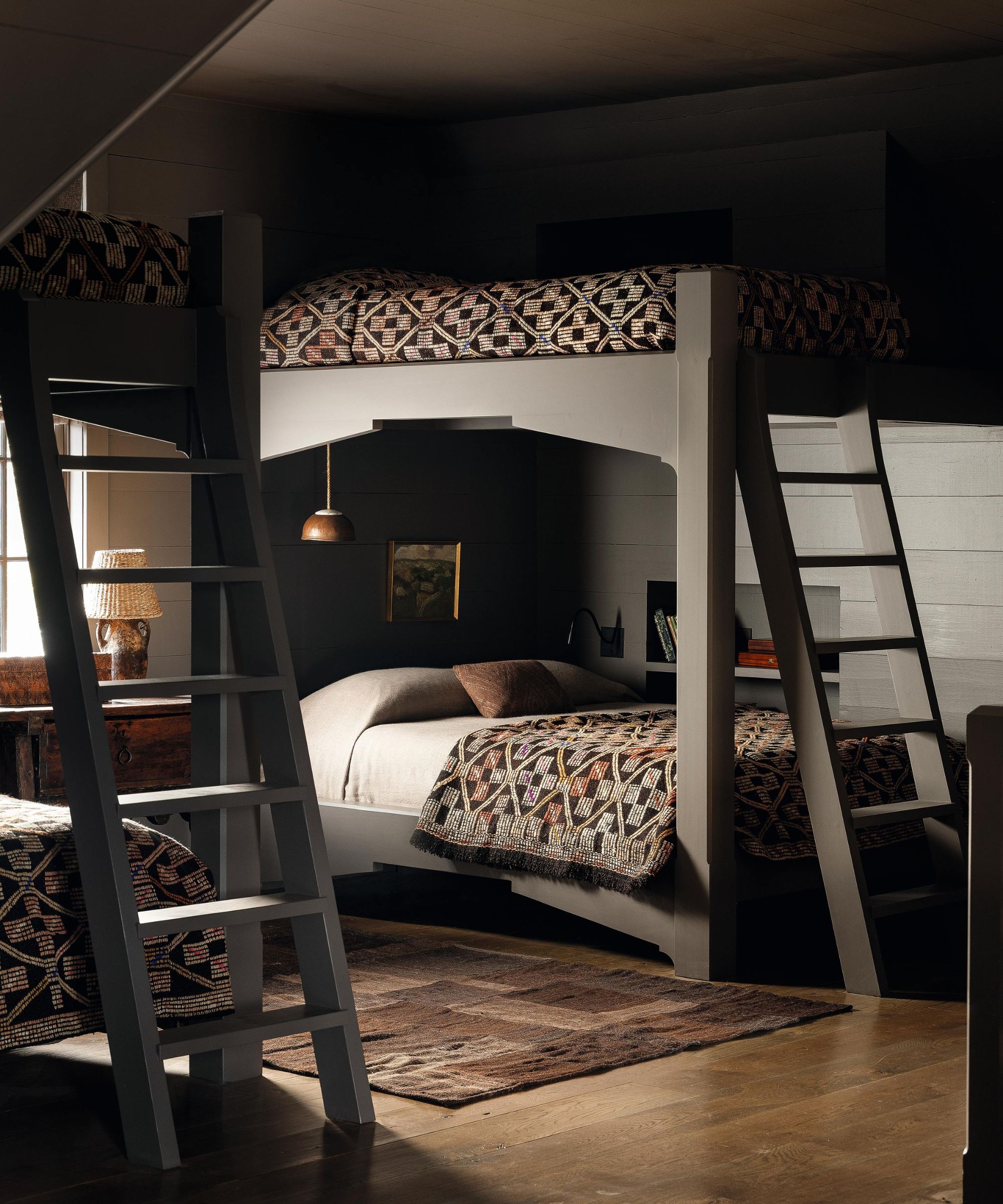 a moody dark brown painted childrens room with four bunk beds in a moody farmhouse