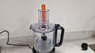 Ready to shred carrot inside the chute of the KitchenAid 9-Cup Food Processor