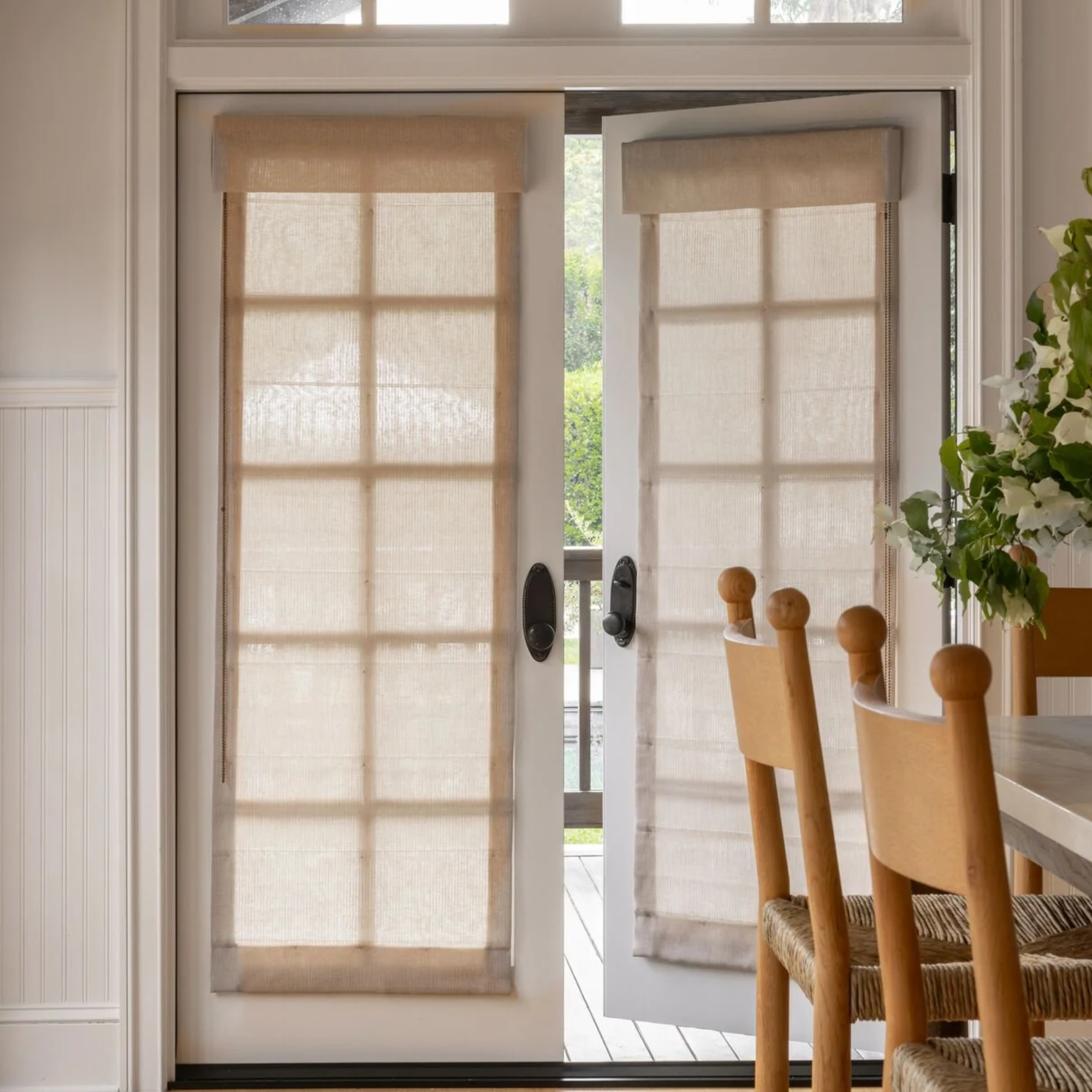 two french doors with roman shades hanging from them