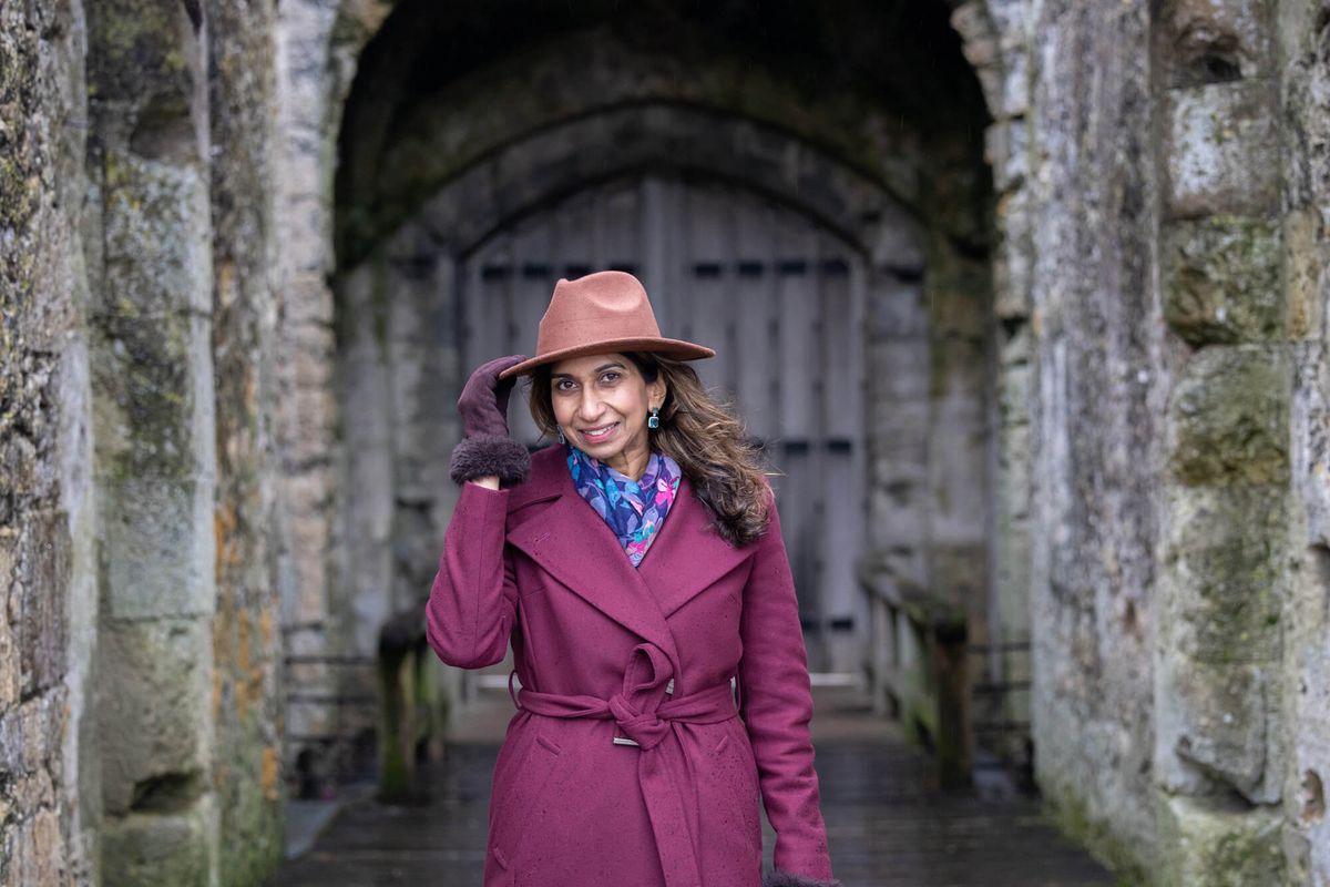 Woman wearing purple coat smiling.