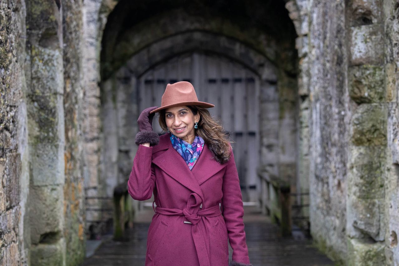Woman wearing purple coat smiling.