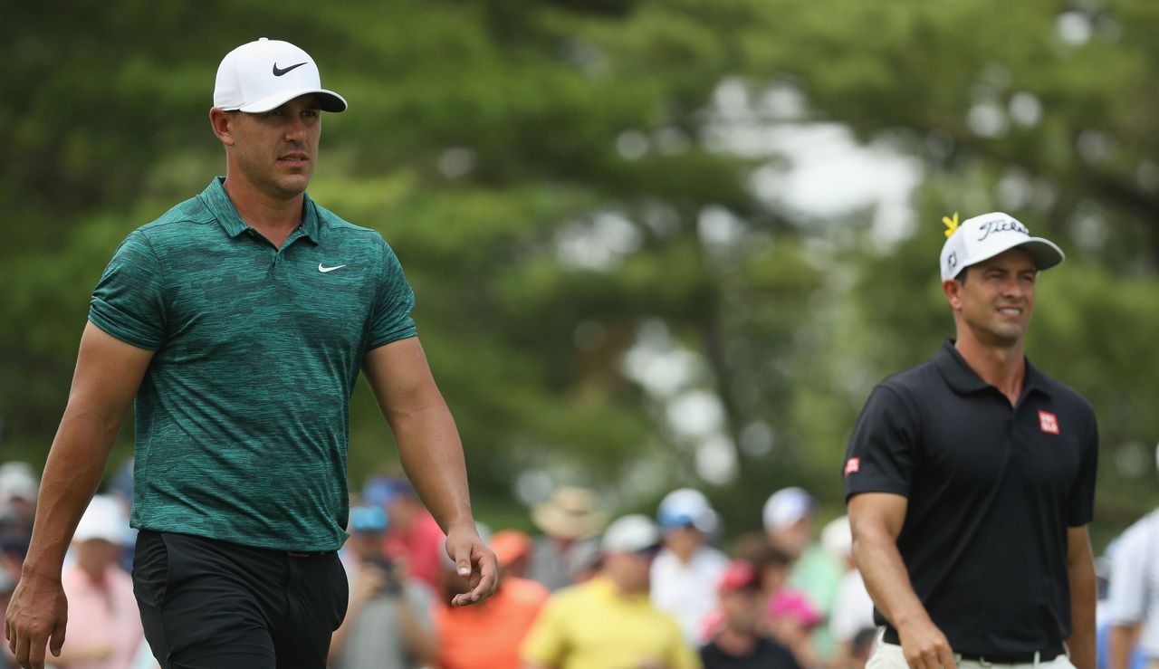 Brooks Koepka and Adam Scott walk down the fairway