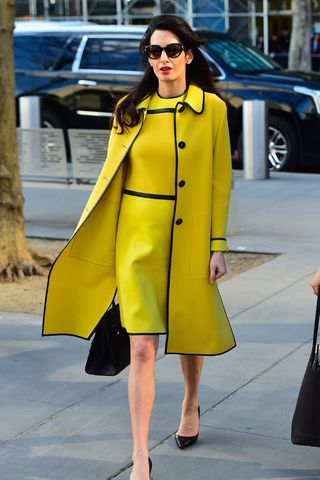 amal clooney wearing a green/yellow dress and coat