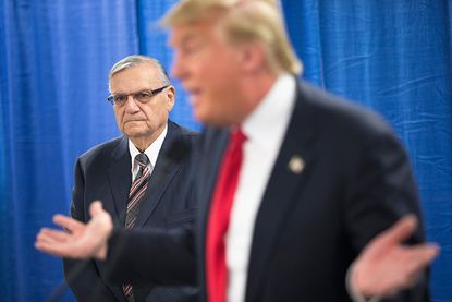 Sheriff Joe Arpaio (L) of Maricopa County, Arizona listens as then-candidate Donald Trump 