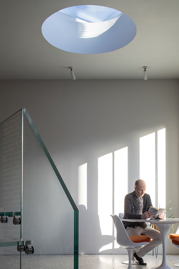 man sitting and reading in white room at The Saddlery