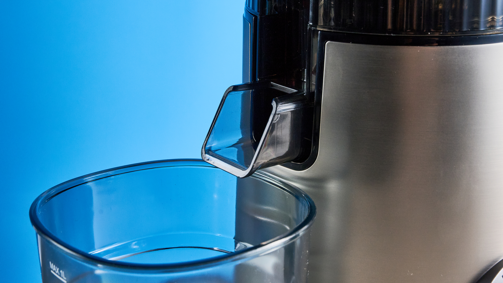 Puraflows Auramist Cold Press Juicer and accessories photographed in front of a blue background