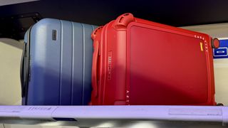 Casetify Bounce Suitcase and Away Carry-On stowed in overhead luggage compartment on an airplane