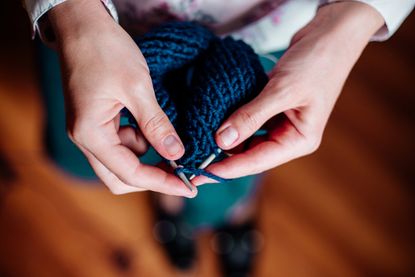 A woman knits.