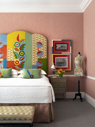 A bedroom with patterned headboard