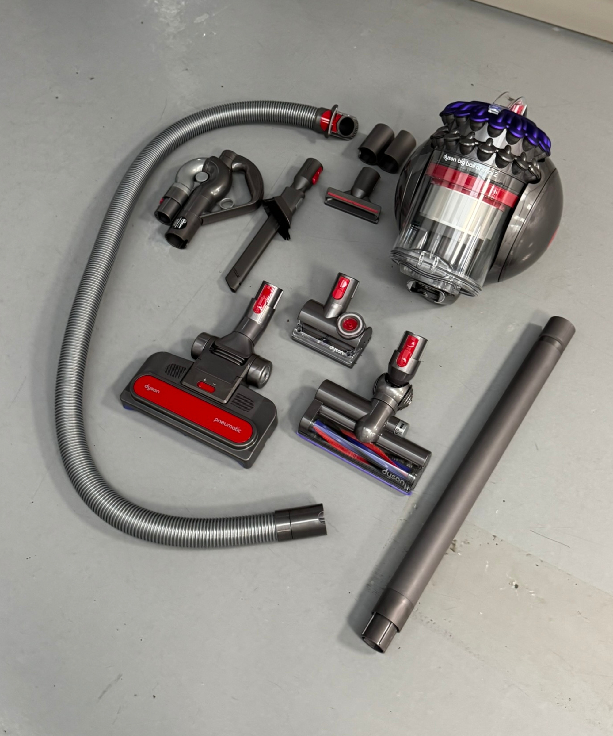 All parts and attachments included with the Dyson Big Ball Turbinehead on gray floor in Future test center.