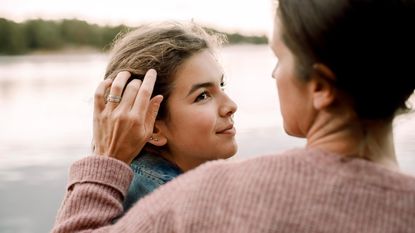 A mom brushes away hair out of her daughter's face.