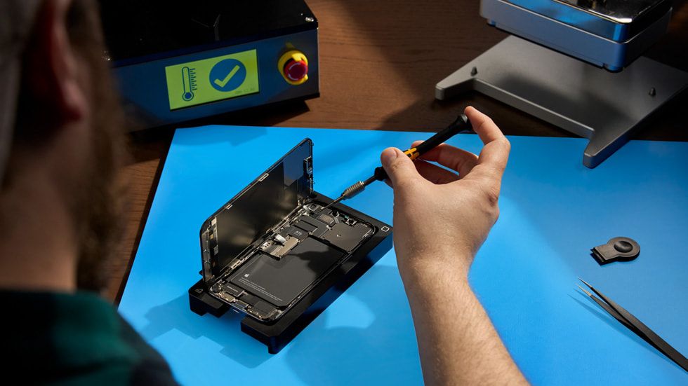 A photo of a person repairing an iPhone