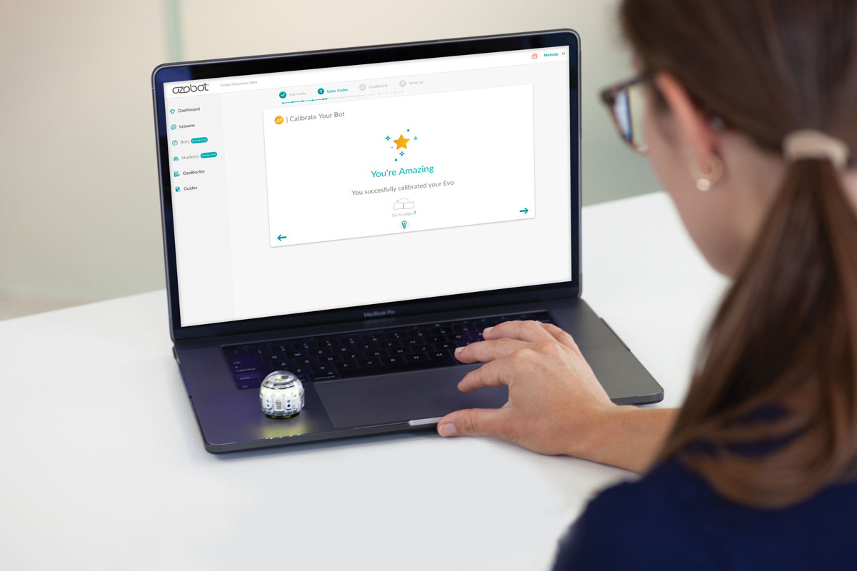 Woman using laptop to control Ozobot