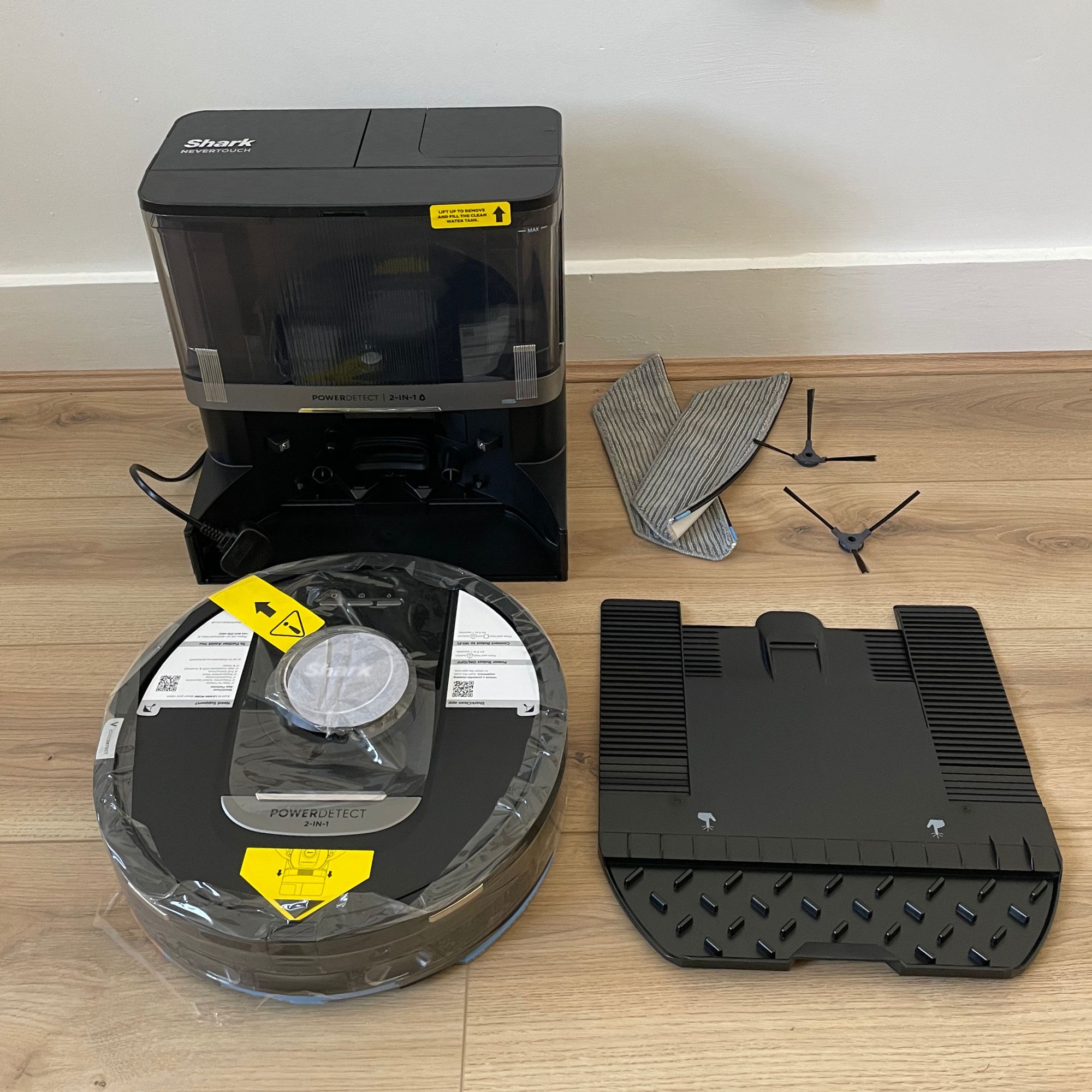 Components of the Shark robot vacuum cleaner and mop on wooden floor