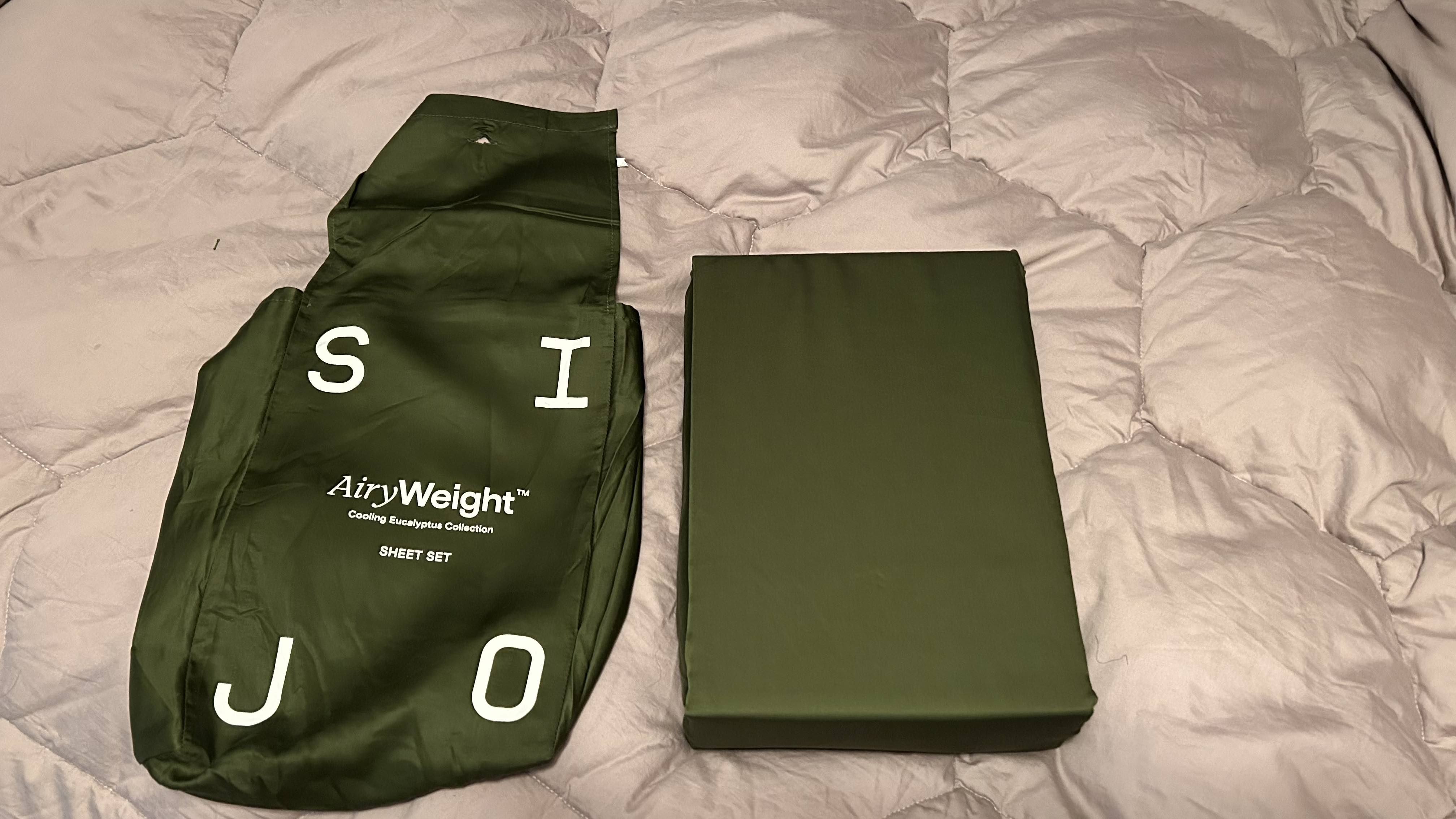 SIJO AiryWeight Eucalyptus Sheet Set packaging and set on a white comforter.