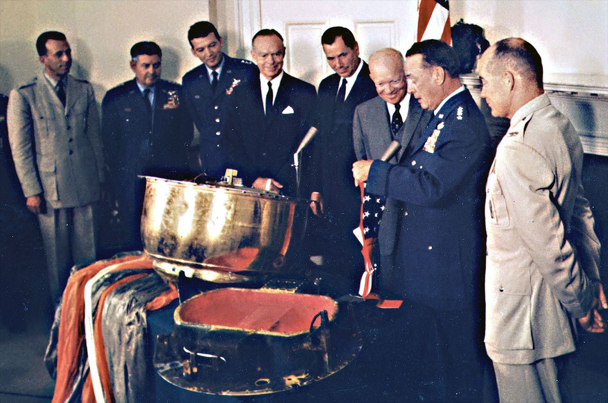 Gen. Thomas White (at right) presents the American flag flown on board the Discoverer XIII reentry capsule to President Dwight Eisenhower at the White House on Aug. 15, 1960.