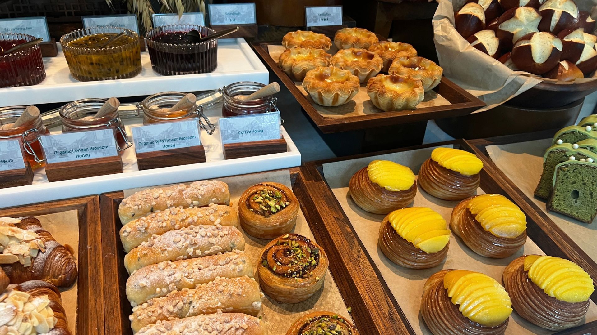 A selection of pastries including criossants, choux buns and matcha banana bread on a breakfast buffet