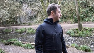 Man wearing ThruDark Centurion Alpine Jacket during walk in the woods