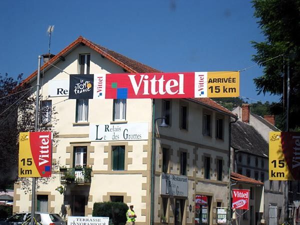 Under the 15 kilometre banner. The climb begins at Besse-et-Saint-Anastaise with 11 kilometres remaining.