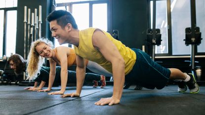 Man and a woman doing push ups to build muscle